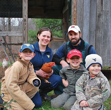 The Kenny family holding a chicken